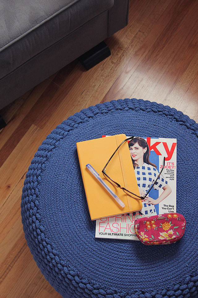 notebook and magazine stack on blue knitted pouf