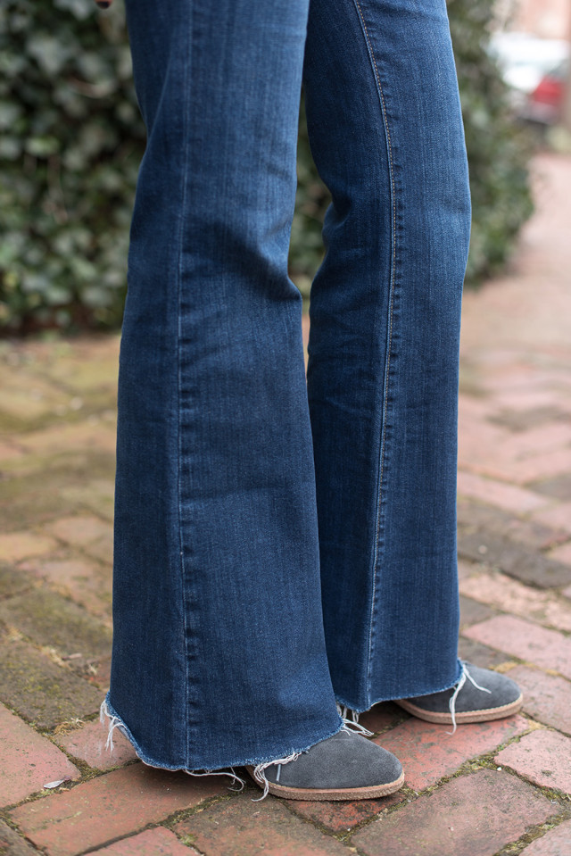 Flare jeans and grey suede booties worn with a black and white polka dot shirt