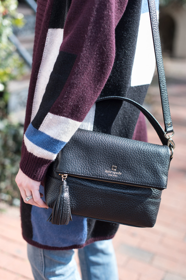 Kate Spade purse with tassel and a color block cardigan sweater with a pair of cropped frayed-hem cropped flare jeans